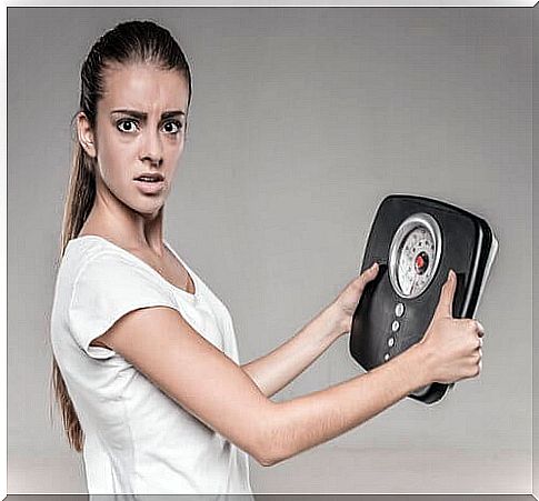 Woman holding a weighing scale in her hands 