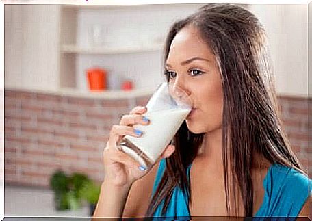 A woman drinking a glass of milk. 