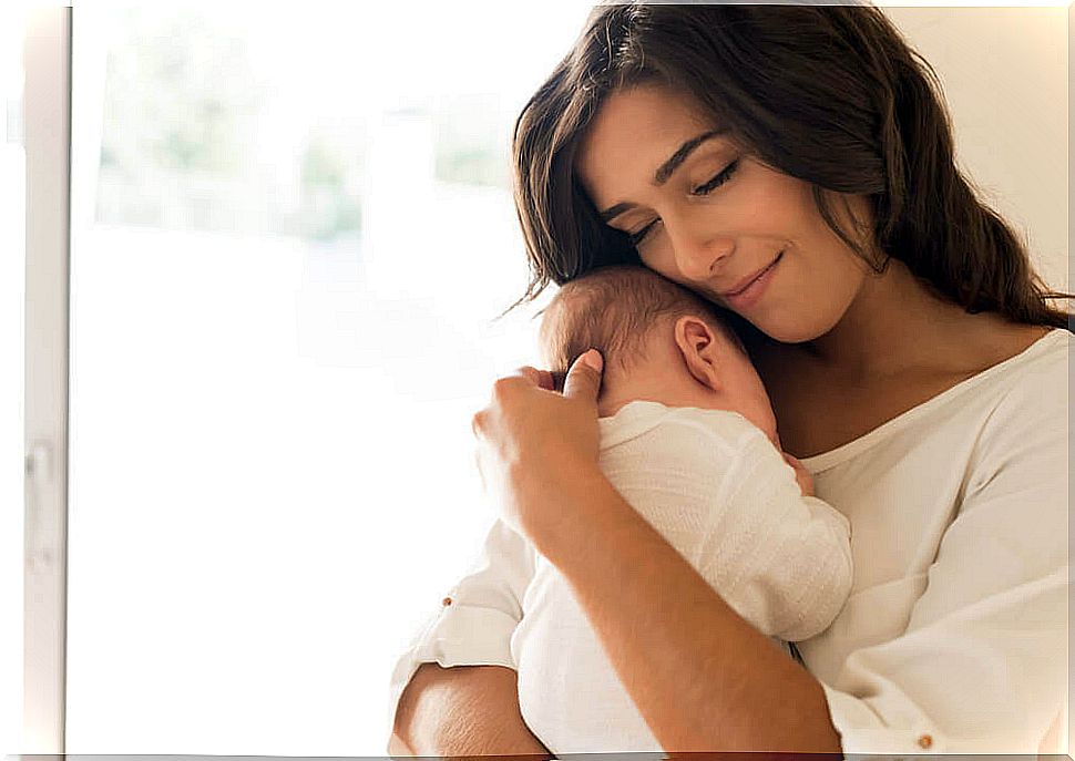 Baby falling asleep in his mother's arms 