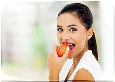 A woman crunching into an apple full of pectin